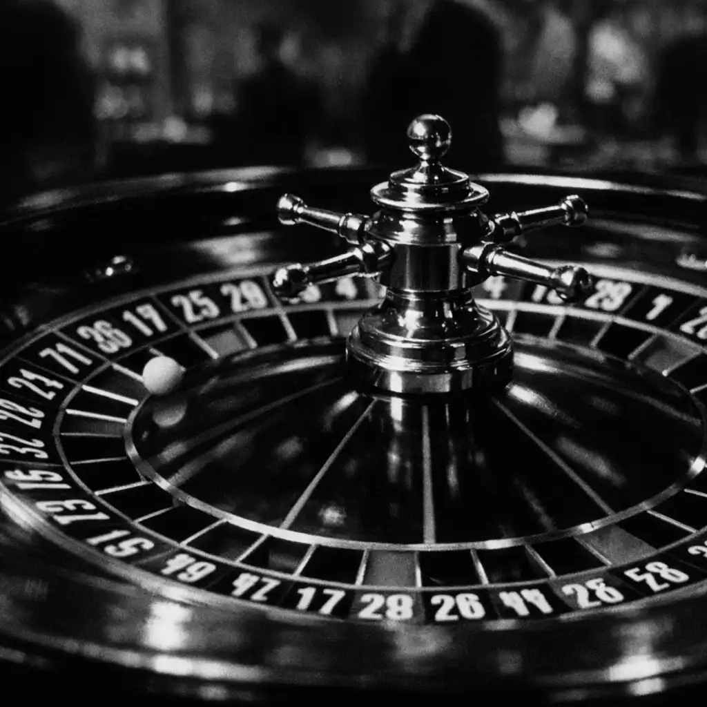 A black-and-white film still from Bob le Flambeur (1956) showing a spinning roulette wheel in sharp focus with a blurred background.