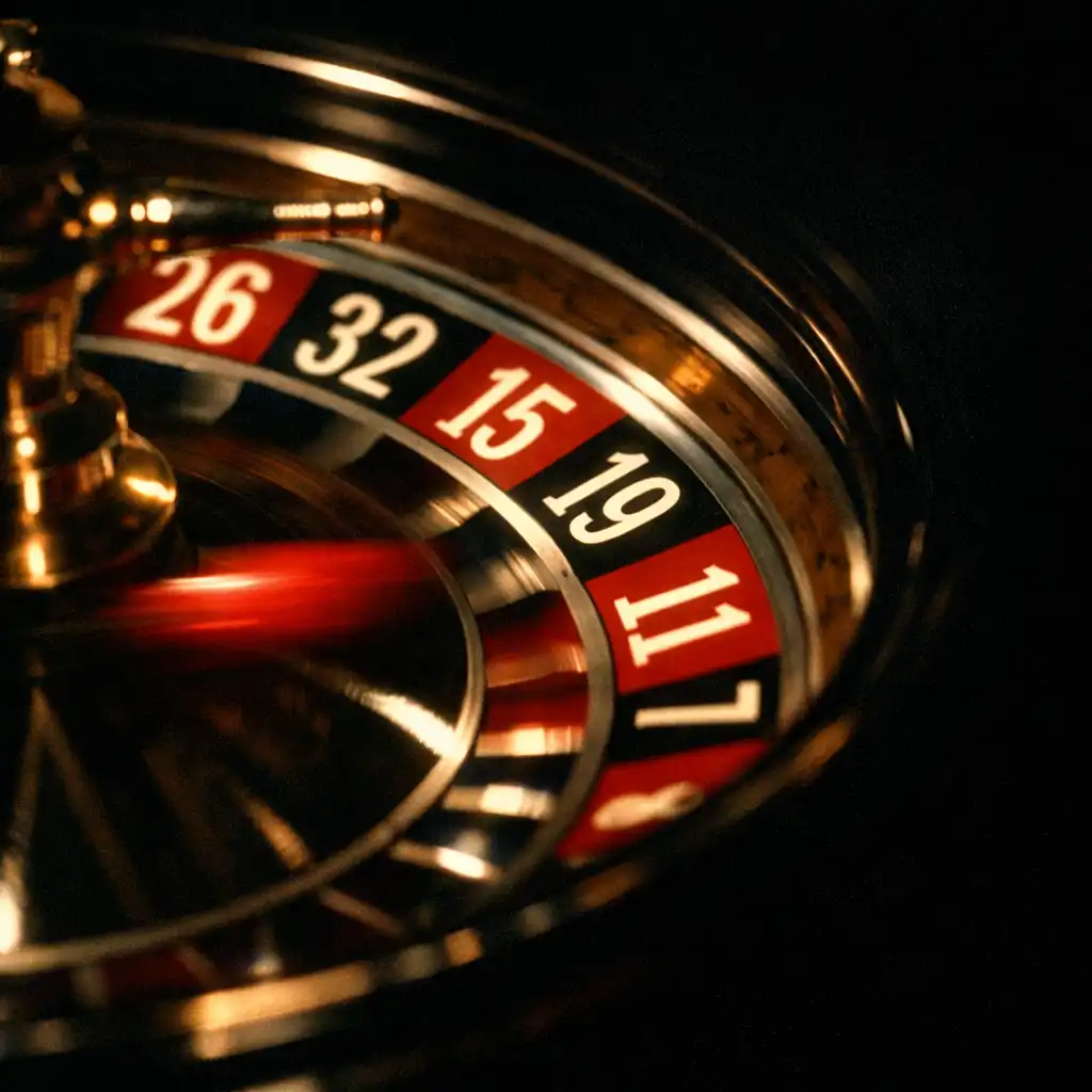 Close-up of a roulette wheel in motion with a crimson blur and warm white highlights on the numbers